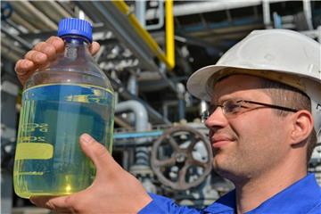Ein Ingenieur von der TU Bergakademie Freiberg hält eine Flasche mit synthetisch hergestelltem Benzin in den Händen. Foto: Hendrik Schmidt