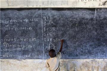 Ein Junge löst in einer Schule in Burundi an der Tafel Mathematikaufgaben. Foto: Tom Schulze