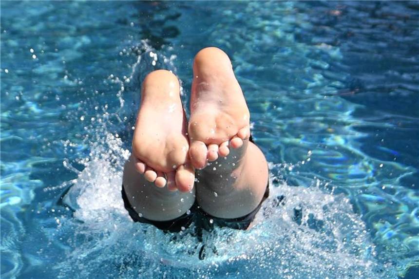 Freibäder steuern auf Besucherrekord zu Ein Junge springt mit einem Kopfsprung in das Wasser des Freibad Bornekamp. Foto: Bernd Thissen/Symbolbild