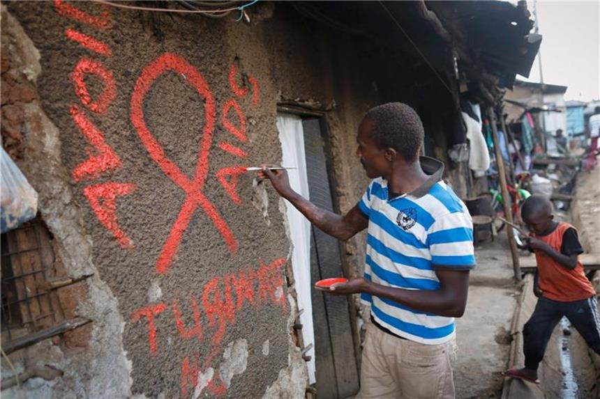 Kampf gegen Aids weniger erfolgreich als erhofft Ein junger Mann malt eine rote Aids-Schleife auf eine Wand im Kibera-Slum und schreibt in roten Buchstaben den Slogan „Avoid AIDS“. Foto: Dai Kurokawa/EPA/Archiv