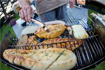 Ein junger Mann wendet am 23.08.2016 bei angenehm warmen Temperaturen in einem Garten in Fellbach (Baden-Württemberg) ein Stück Putenfleisch auf einem Grill. Auch in den nächsten Tagen wird es in Baden-Württemberg viel Sonnenschein und somit bestes Grillwetter geben. Foto: Christoph Schmidt/dpa +++(c) dpa - Bildfunk+++ | Verwendung weltweit