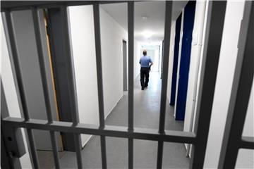 Ein Justizbeamter geht über den Flur eines Zellentrakts der Abschiebehafteinrichtung. Foto: Arne Dedert/Archiv
