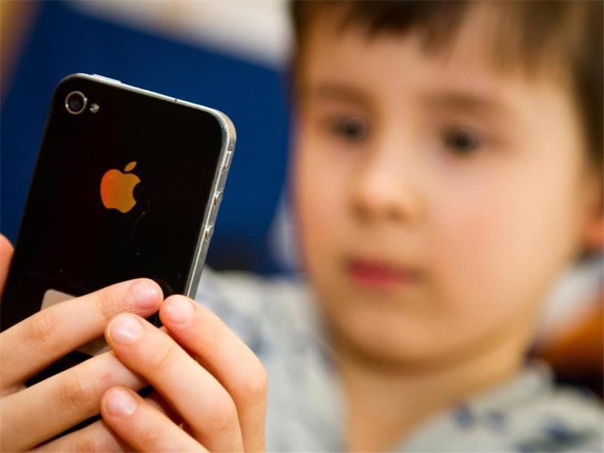 WHO: Digitale Werbung für ungesundes Essen macht Kinder dick Ein Kind blickt auf ein iPhone. Foto: Ole Spata/Illustration