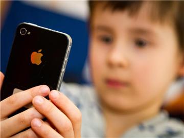Ein Kind blickt auf ein iPhone. Foto: Ole Spata/Illustration