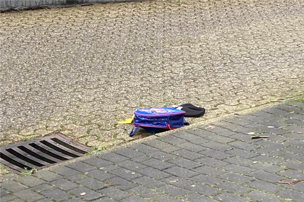 Polizei-Großeinsatz mit Hubschrauber: Hinweise auf Bluttat – Täter flüchtig – Videos und Fotos Ein Kinderrucksack und eine Mütze liegen auf der Fahrbahn.