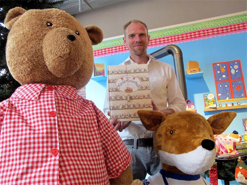 Die Kinder-Klassiker kommen wieder Ein Klassiker des Coppenrath-Verlags wird wieder neu aufgelegt: Pressesprecher Tomas Rensing hält das »Kinderliederbuch« von Antje Vogel in den Händen. Daran baumelt eine kleine Mundharmonika.