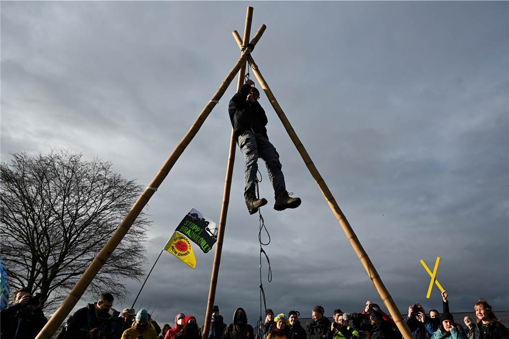 Lützerath von Aktivisten überlaufen: Blockaden und Glasflaschen – „Wir geben jetzt alles“ Ein Klimaschutzaktivist hängt während des Aktionstrainings an einem Tripod um die bevorstehende Räumung durch die Polizei zu proben.