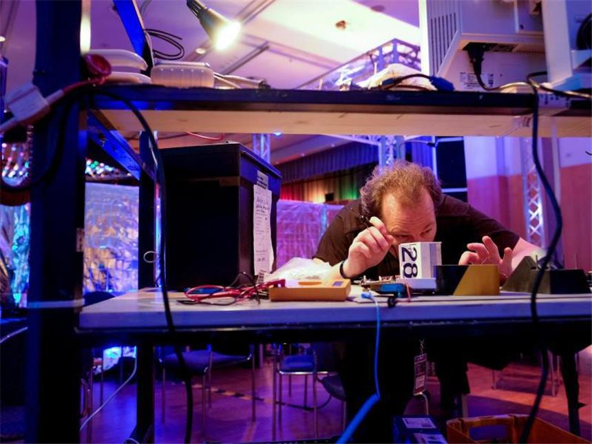 Europas Hacker debattieren in Hamburg Ein Kongressbesucher arbeitet mit einem Lötkolben an einem Computerbauteil. Foto: Axel Heimken