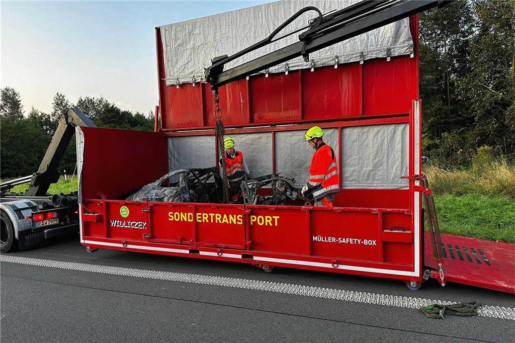 Ein Kran birgt den verunglückten, ausgebrannten Porsche an der A44.