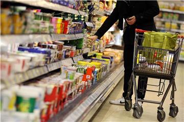 Ein Kunde steht in Köln in einem Supermarkt am Kühlregal. Foto: Oliver Berg/Archiv