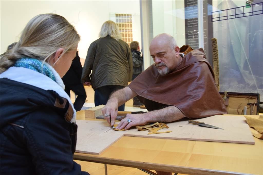 Das LWL-Römermuseum feiert Geburtstag mit Hunderten Besuchern Ein Legionär zeigt einer jungen Besucherin, wie die Römer damals Lederbeutel fertigte.