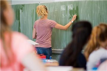Ein Lehrerin schreibt an einer Schultafel. Foto: Julian Stratenschulte/Archiv