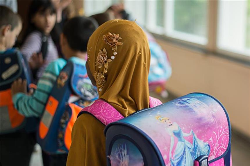 Kopftuchverbot für Mädchen umstritten Ein Mädchen mit Kopftuch steht vor einem Klassenzimmer. Das NRW-Integrationsministerium hatte zuvor angekündigt, ein Kopftuchverbot für junge Mädchen zu prüfen. Foto: Wolfram Kastl/Illustration