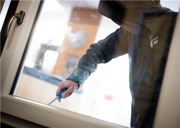 Ein Mann demonstriert, wie einfach es für einen Einbrecher ist, mit Hilfe eines stabilen Schraubenziehers ein geschlossenes Fenster von außen zu öffnen. 