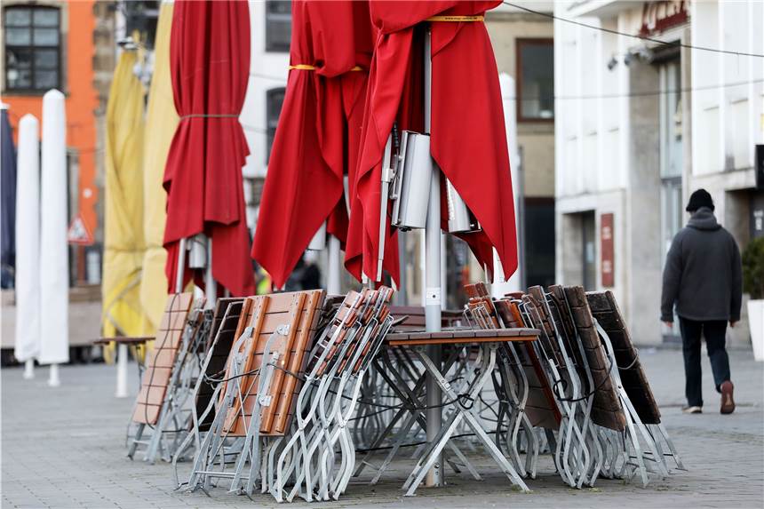 Lockdown-Betroffene haben wenig Aussicht auf Entschädigung Ein Mann geht im vergangenen Jahr auf dem Kölner Heumarkt an zusammengestellten Tischen und Stühlen eines geschlossenen Restaurants vorbei.