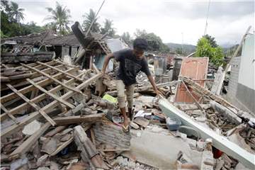 Ein Mann geht über die Trümmer eines vom Erdbeben zerstörten Hauses.Foto: Firdia Lisnawati/AP