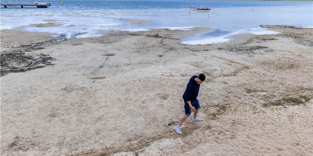 Es ist viel zu trocken: „Faktisch haben wir bereits eine Wasserkrise“ Ein Mann markiert die normale Wasserlinie am Strand.