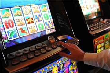 Ein Mann spielt in einer Spielbank an einem Spielautomaten. Foto: Angelika Warmuth/Archiv