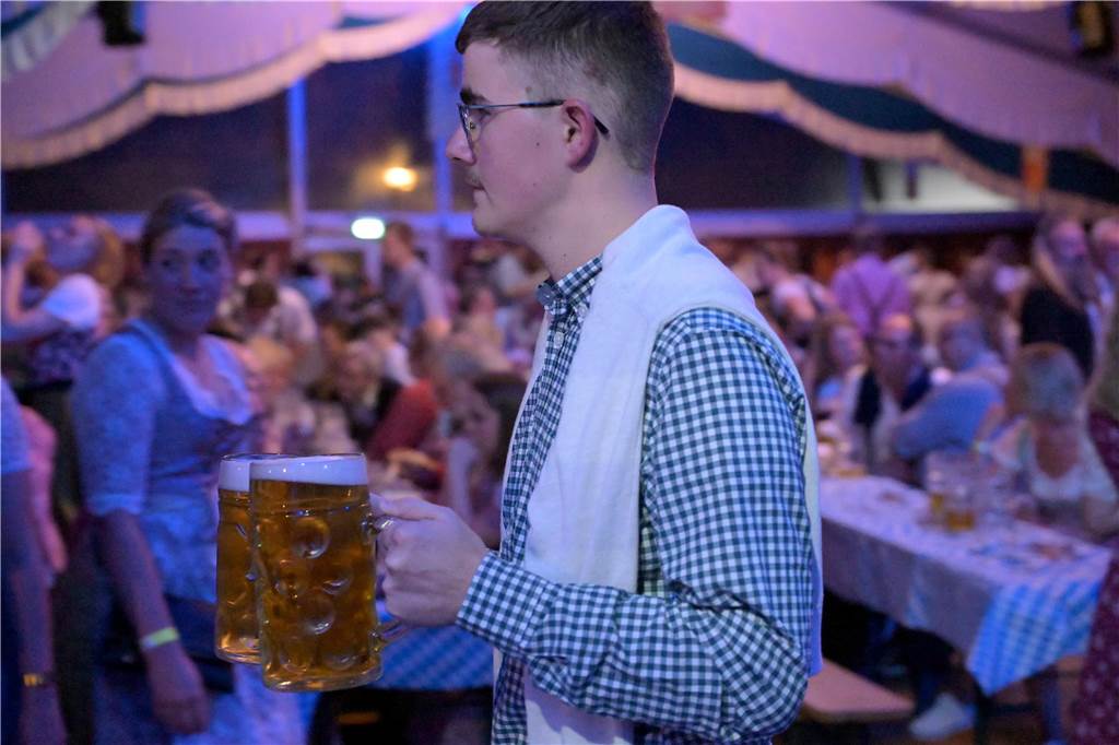 Ein Mann trägt zwei Maß Bier