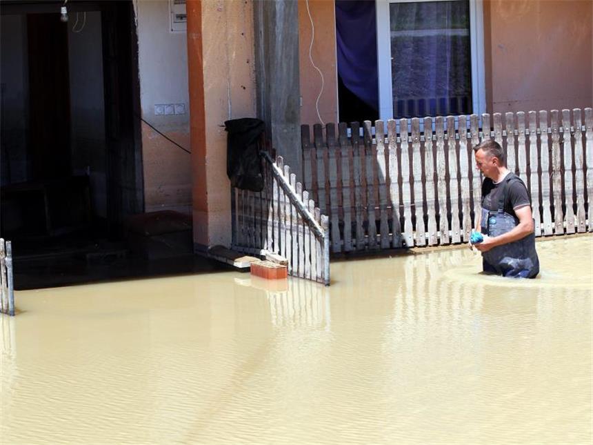 Im Hochwasser-Gebiet wächst die Angst vor Seuchen Ein Mann watet im Norden vom Bosnien-Herzegowina durch eine überflutete Straße. Foto: Fehim Demir