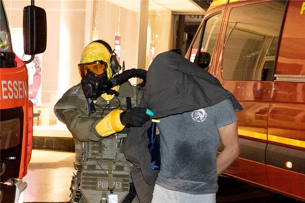Ein Mann wird von einem Beamten des Spezialeinsatzkommandos (SEK) mit Schutzmaske in Gewahrsam genommen. Anti-Terror-Ermittler haben in Castrop-Rauxel im nördlichen Ruhrgebiet einen 32-Jährigen und seinen sechs Jahre jüngeren Bruder (Foto) festgenommen, der einen islamistischen Anschlag vorbereitet haben soll. 