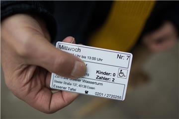 Ein Mann zeigt seine Berechtigungskarte vor dem Eingang zur Essener Tafel: Die Hilfsorganisation hatte seit dem 10. Januar Ausländer als Neukunden bei der Lebensmittelausgabe abgelehnt und dies mit einem angeblich zu hohen Ausländeranteil begründet. Foto: Rolf Vennenbernd