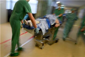Ein Mediziner-Team fährt in einer Klinik nach einer Operation einen Patienten im Bett durch den Klinikflur. Foto: Felix Kästle/Archiv