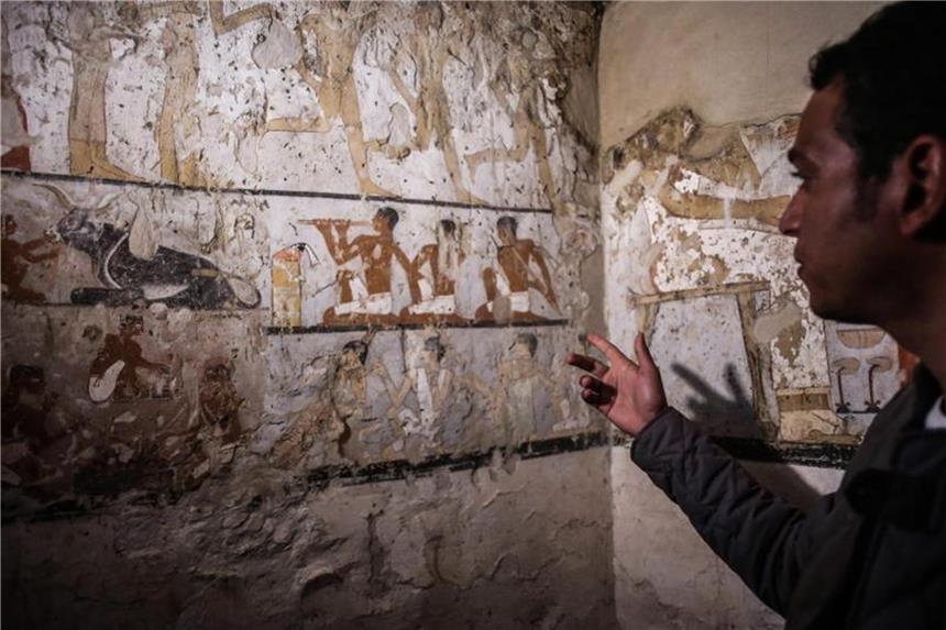 4000 Jahre altes Grab bei Pyramiden in Ägypten entdeckt Ein Mitarbeiter der Ausgrabungen deutet auf die Wandmalereien in einem neu entdeckten Grab in der Nähe der Cheops-Pyramiden. Foto: Fayed El-Geziry