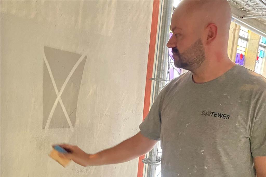 Renovierung der Sixtus-Kirche dauert länger: 300 Schwämme gegen den Ruß Maler mit Schwamm an Kirchenwand