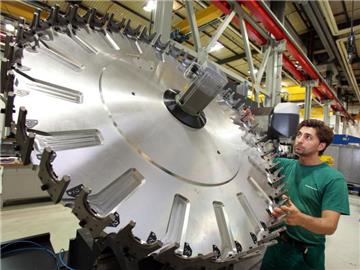 Ein Mitarbeiter der Gildemeister AG kontrolliert im Werk in Bielefeld ein Werkzeugscheibenmagazin. Foto: Oliver Krato/Archiv