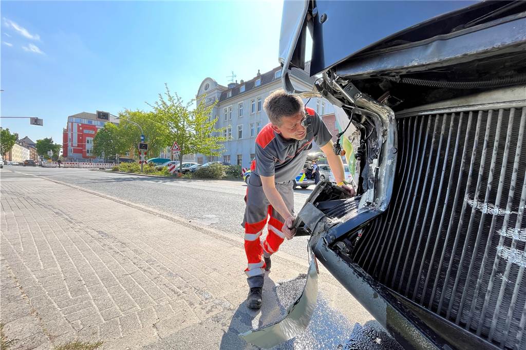 Hafen Dortmund: Bahn rammt Schulbus und schleift ihn zehn Meter mit Ein Mitarbeiter des Abschleppdienstes begutachtet am Dienstag (3.5.) die Schäden an einem Schulbus, der von einer Lok im Hafen gerammt worden ist.