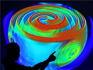 Ein Mitarbeiter des Max-Planck-Instituts für Gravitationsphysik in Potsdam erläutert anhand einer Computersimulation die Ausbreitung von Gravitationswellen. Foto: Michael Hanschke/Archiv