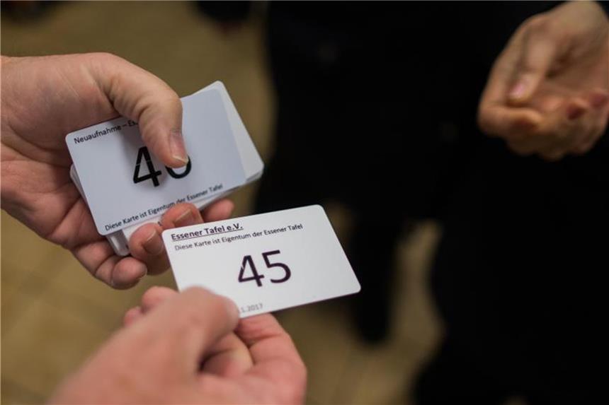 Tafel veröffentlicht neue Voraussetzungen für Kundenkarten Ein Mitarbeiter verteilt Einlasskarten für die Neuaufnahme. Foto: Rolf Vennenbernd