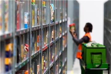 Ein Mitarbeiter von Amazon Fresh packt im Depot der Firma die bestellten Waren in eine Transporttasche. Foto: Monika Skolimowska