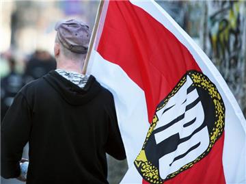Ein Mitglied der rechtsextremen NPD mit einer Fahne der Partei. Foto: Stephan Scheuer