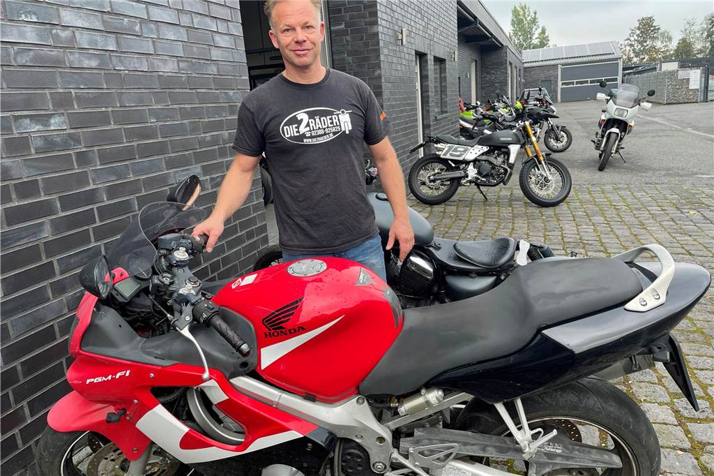 Benedikt Kutschat steht mit dem vergessenen Motorrad vor seiner Werkstatt.