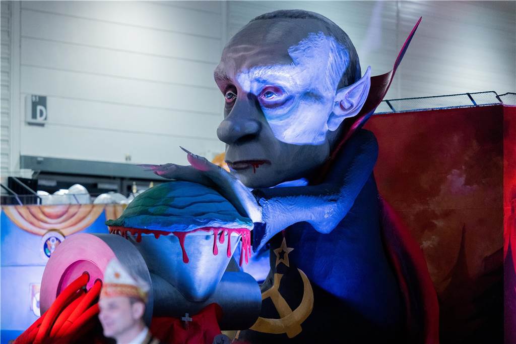Karneval 2023 in NRW Ein Mottowagen, der Russlands Präsidenten Wladimir Putin zeigt, wie er die Welt durch den Fleischwolf dreht, wird beim Richtfest für den Kölner Rosenmontagszug in der Koelnmesse vorgestellt.
