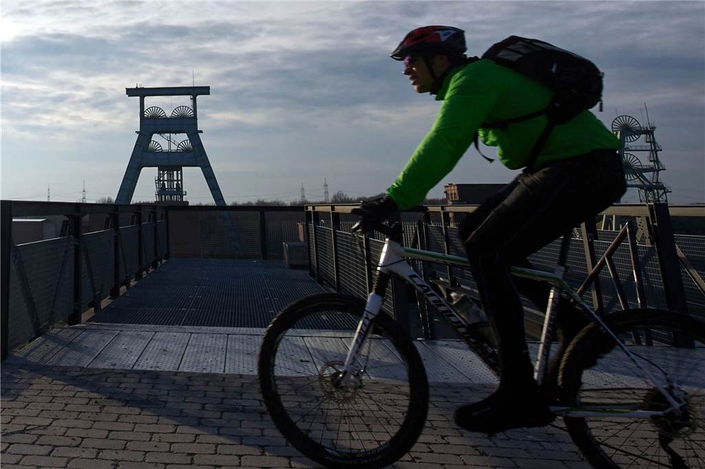 Hier wird der Oster-Spaziergang im Kreis Recklinghausen zum Hit Ein Mountainbiker fährt auf der Halde Hoheward in Herten am Förderturm der ehemaligen Zeche Ewald vorbei. Hier kann man nicht nur laufen, sondern auch ausgezeichnet biken.