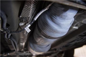 Ein nachgerüsteter SCR-Katalysator ist am Unterboden eines Autos zu sehen. Foto: Marijan Murat/Archiv