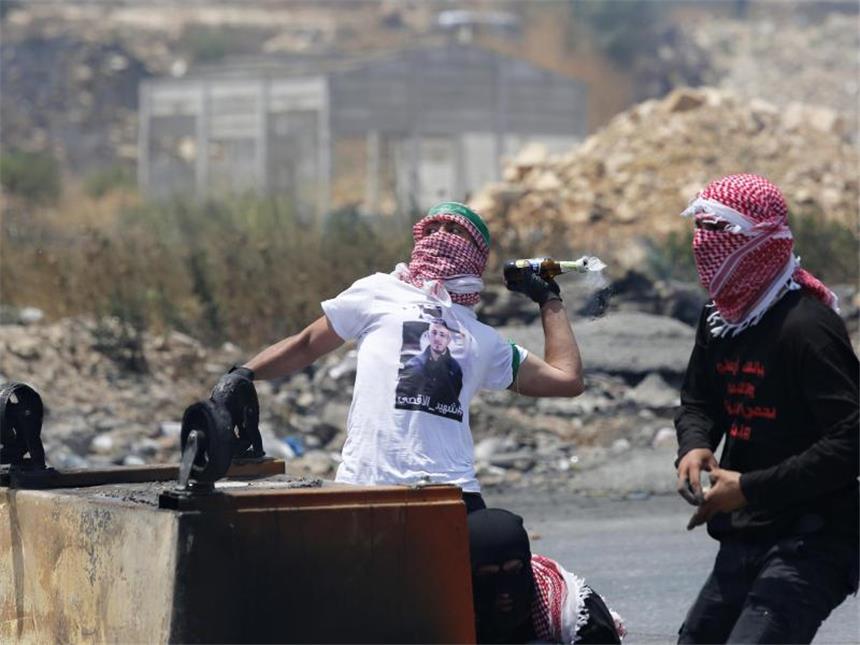 Tempelberg-Krise: Israel baut Metalldetektoren wieder ab Ein Palästinenser wirft einen Molotow-Cocktail in Richtung israelischer Soldaten. In den vorangegangenen Tagen war die Situation eskaliert. Foto: Nasser Shiyoukhi/Archiv