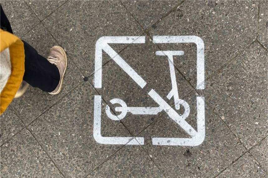 Ärgernis und Gefahr: Städte wollen Obergrenze für E-Tretroller Ein Piktogramm auf einem Gehweg zeigt, dass E-Scooter-Fahrer hier nicht fahren und wild parken dürfen.