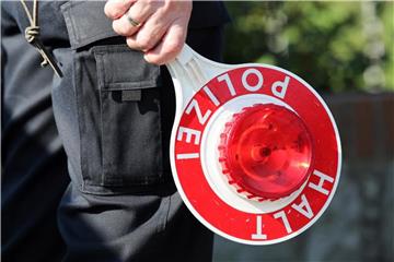 Ein Polizeibeamter hält eine Polizeikelle. Foto: Bodo Marks/Archiv