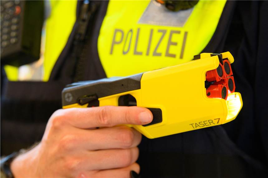 Elektroschock-Pistolen: Alle Polizisten in fünf großen NRW-Städten erhalten Taser Ein Polizeibeamter hält im Rahmen der Pressekonferenz des Polizeipräsidenten einen Taser 7 in der Hand. (zu dpa «Diskussion um Einsatz von Elektroimpulswaffen nach tödlichen Schüssen auf Flüchtling») +++ dpa-Bildfunk +++
