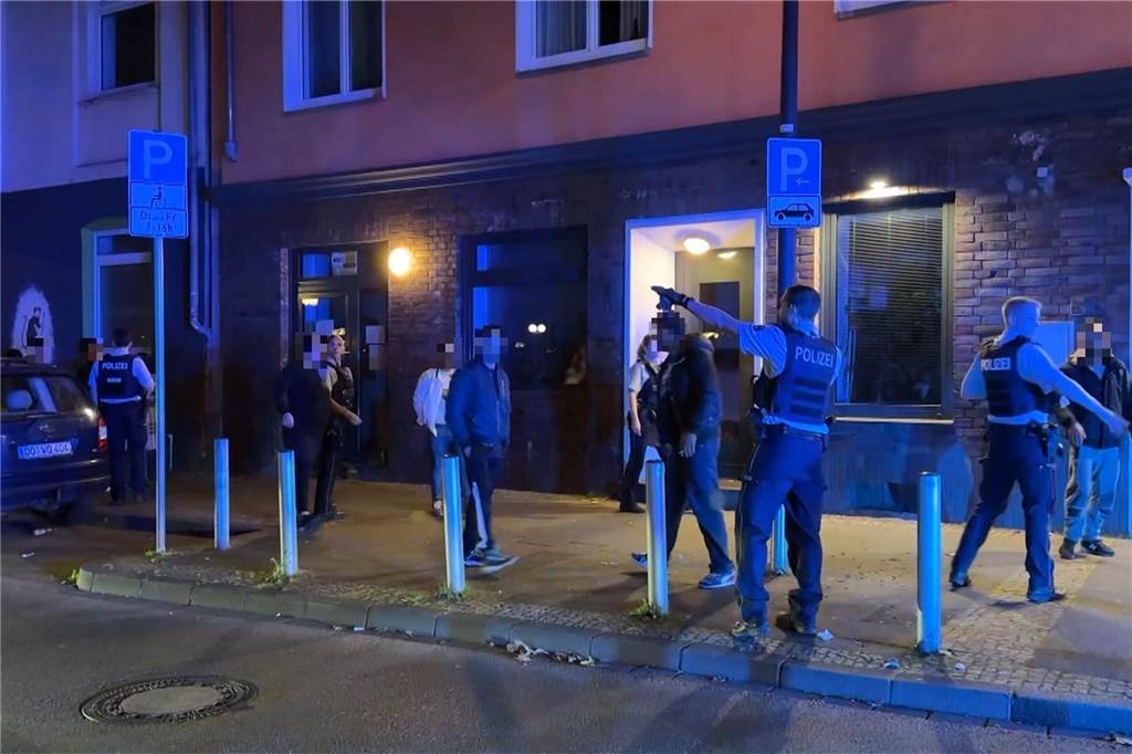 300 Schaulustige bedrängten Polizisten: Wie kommt es zu solchen Situationen? Ein Polizeibeamter weist Umstehende weg vom Einsatzort. Rund 300 Schaulustige hatten am Sonntagabend (24.9.) den Einsatz der Polizei erschwert.