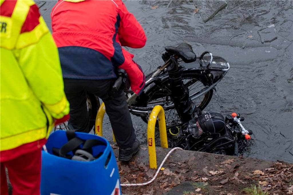 113-Millionen-Raub in Dresden: 20 Polizeitaucher suchen nach Beweisen im Kanal Ein Polizeitaucher hebt ein Fahrrad aus dem Schifffahrtskanal.