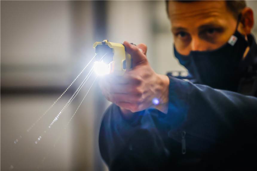 Taser-Tests: „Menschen in der Nordstadt dürfen nicht Versuchskaninchen sein“ Ein Polizist führt bei einer Pressekonferenz in Dortmund einen Taser vor. Die Elektroschock-Pistolen werden in der Nordstadt erprobt.