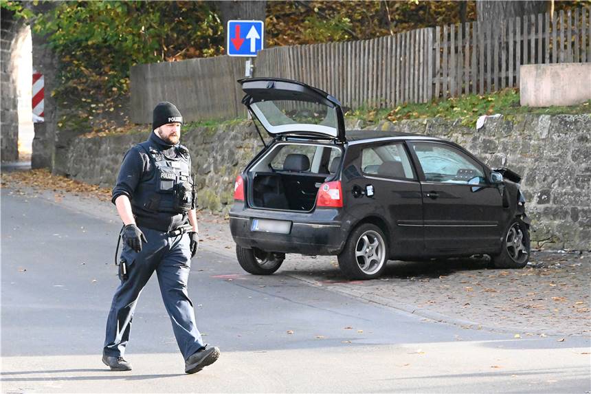 Absichtlich in Kindergruppe gerast: Autofahrer tötet achtjähriges Mädchen Ein Polizist geht an einem VW Polo vor einer Kindertagesstätte im Ortsteil Gertenbach vorbei. Dort soll ein Autofahrer absichtlich in eine Gruppe Kinder gefahren sein.