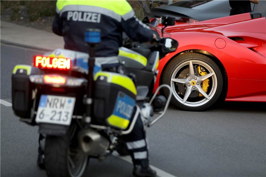 Härtere Strafen für Raser und Falschparker gelten ab Dienstag Ein Polizist hält bei einer Verkehrskontrolle einen Ferrari an.