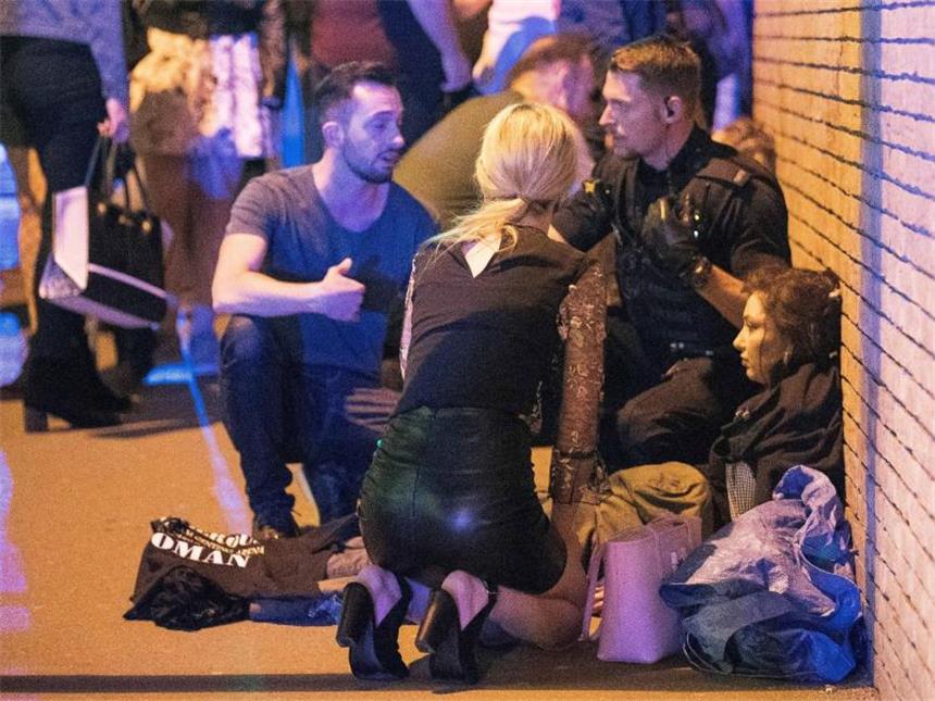 Polizei nach Manchester-Anschlag: Abedi hatte Hintermänner Ein Polizist hilft unweit des Explosionsortes einer verletzten Frau. Foto: Joel Goodman/London News Pictures via ZUMA
