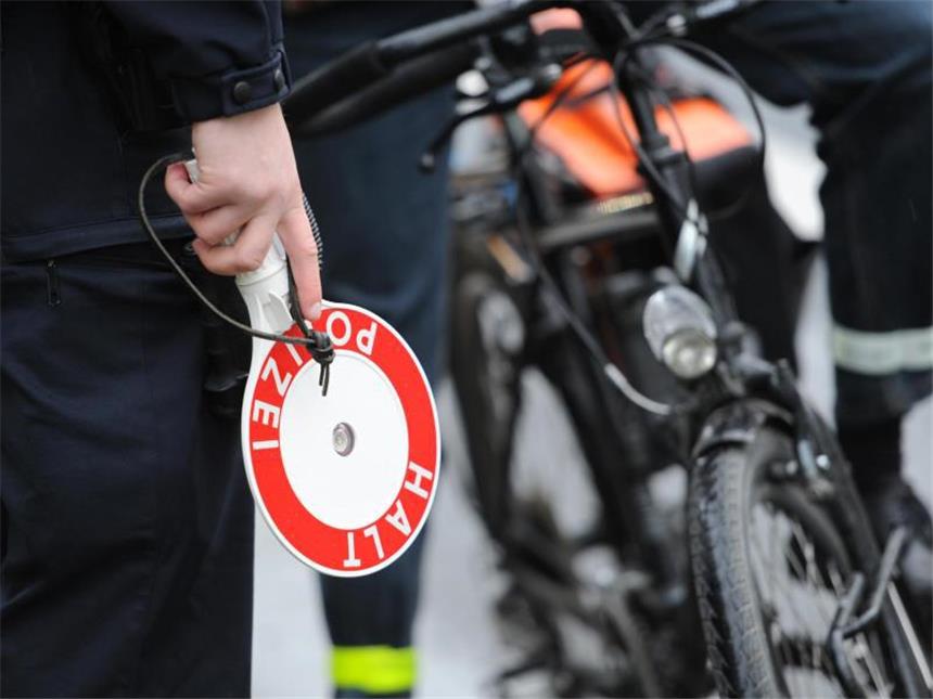 Verkehrsgerichtstag will Promille-Grenze für Radfahrer senken Ein Polizist kontrolliert in der Innenstadt von Frankfurt am Main einen Radfahrer. Foto: Arne Dedert/Archiv